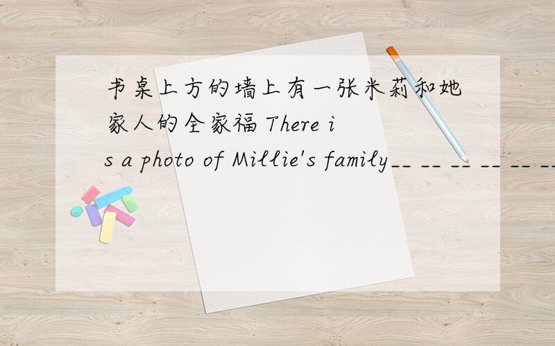 书桌上方的墙上有一张米莉和她家人的全家福 There is a photo of Millie's family__ __ __ __ __ __.